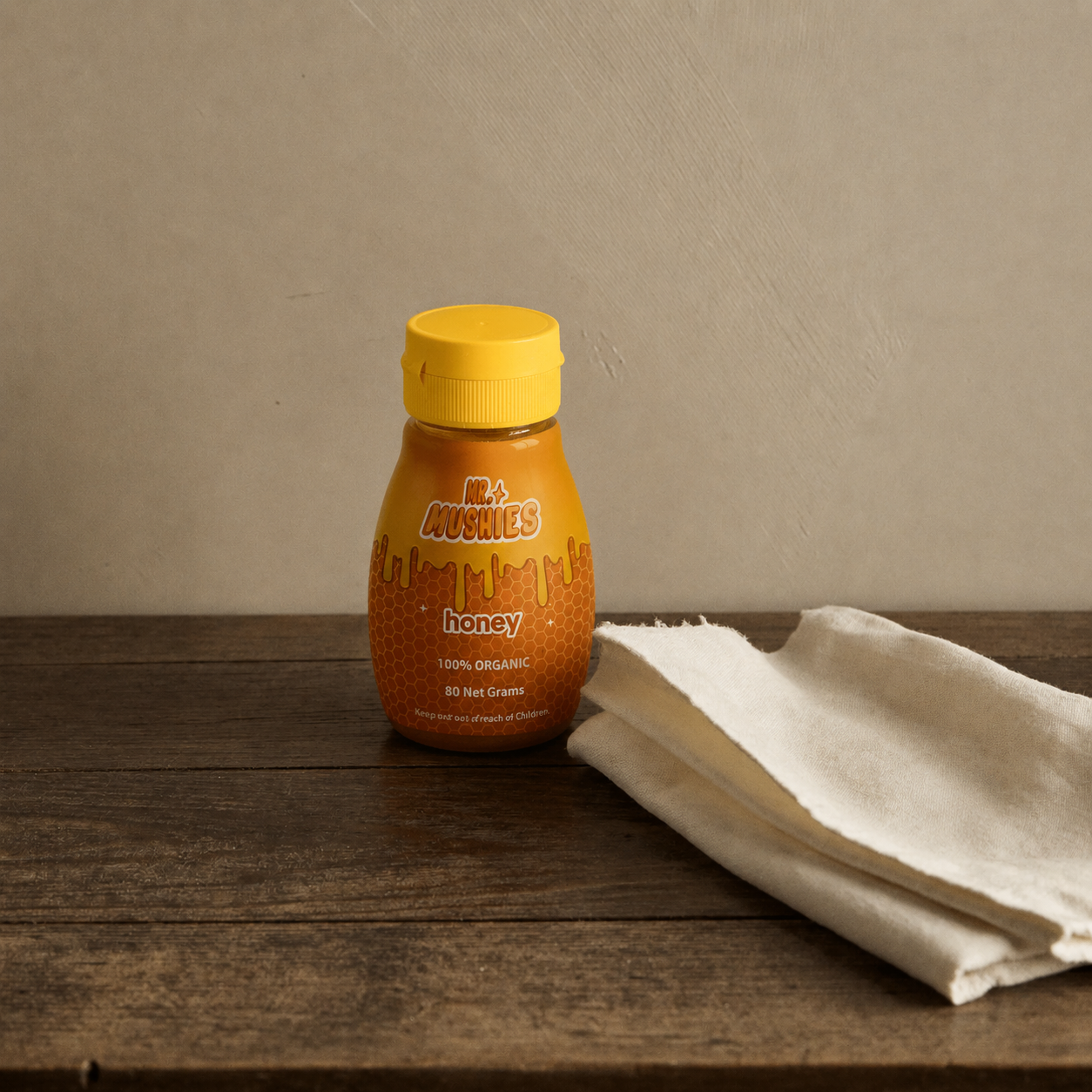 Amber jar of honey on a wooden shelf with linen napkin and dipper